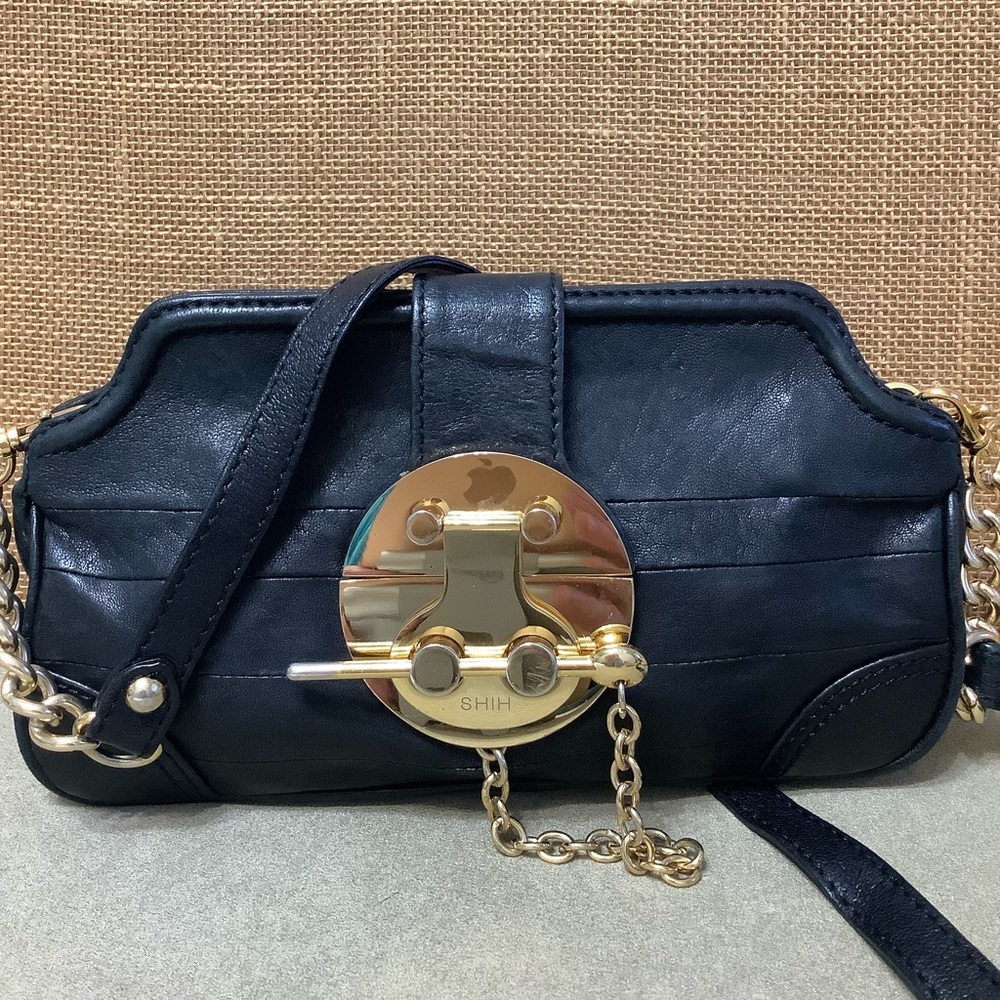 SHIH Black leather purse with gold hardware.